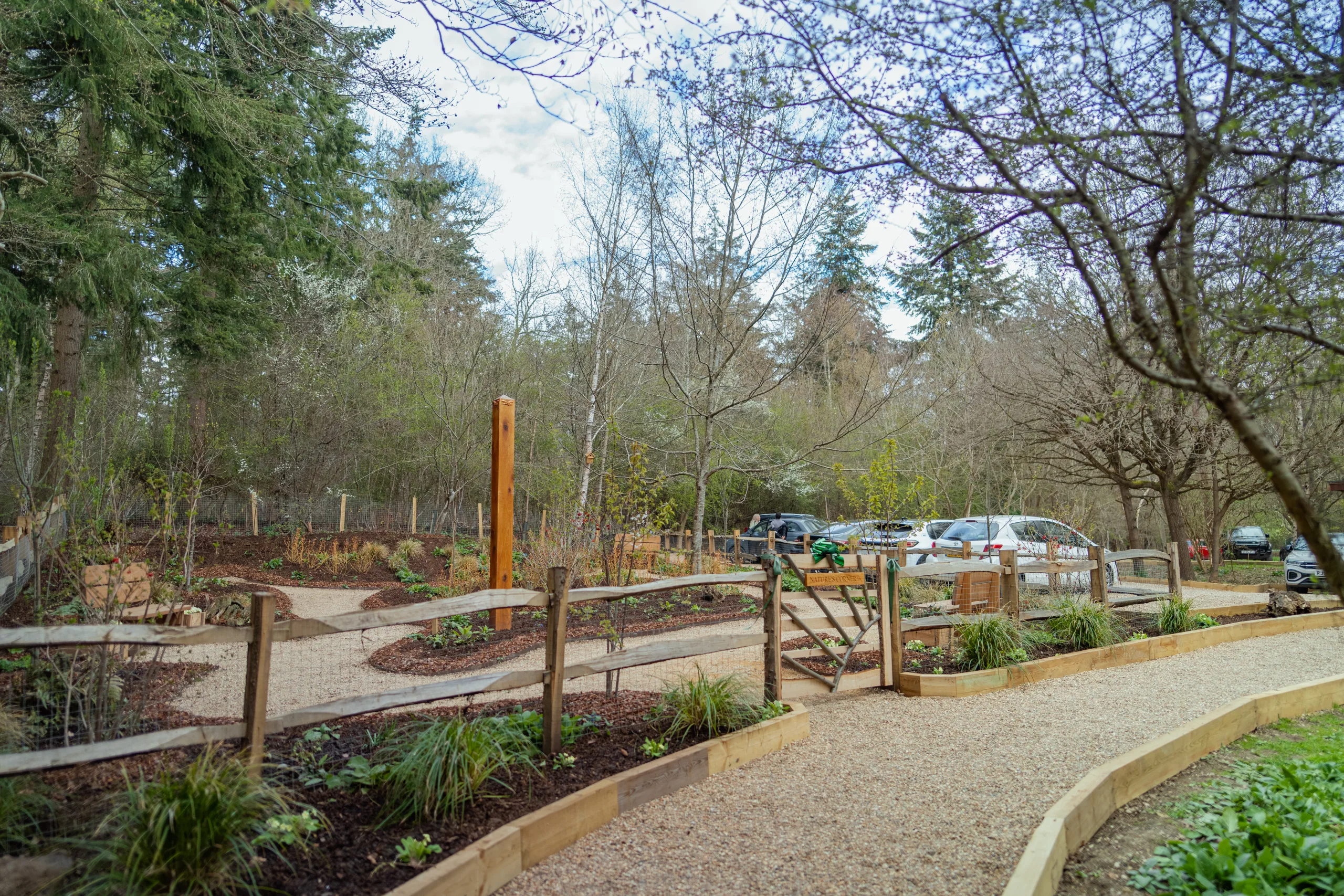 Landscaped memorial garden with winding pathways, planted borders and surrounding woodland at GreenAcres Chiltern Park.